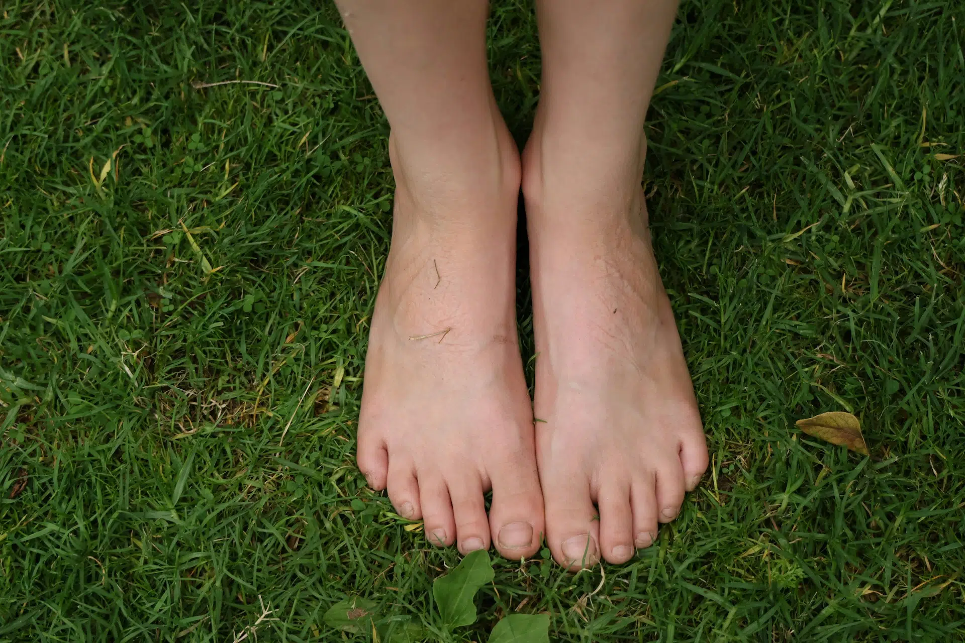 ines-iachelini-uC7MeEYA97o-unsplash Füße stehen auf Wiese als Symbolbild für Grounding