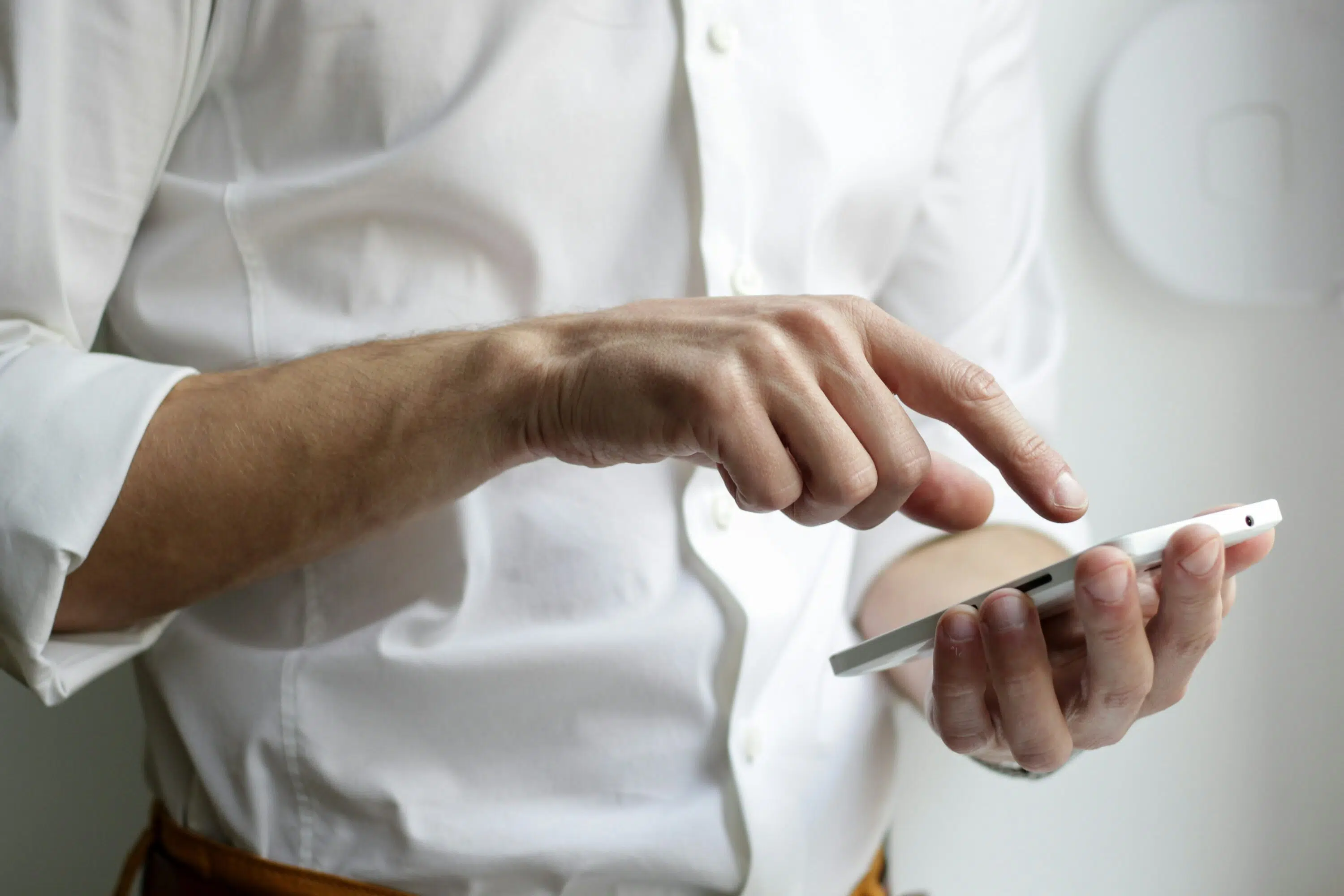 Mann im Anzug tippt mit Finger auf Smartphone